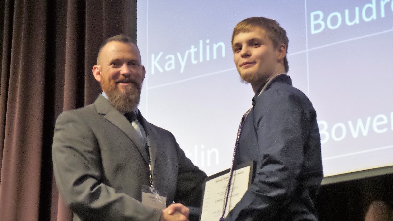 On left is KACC Director Matt Kelley congratulating Cade Bennett, Construction Technology Student from  Donovan High School at the Induction Ceremony.